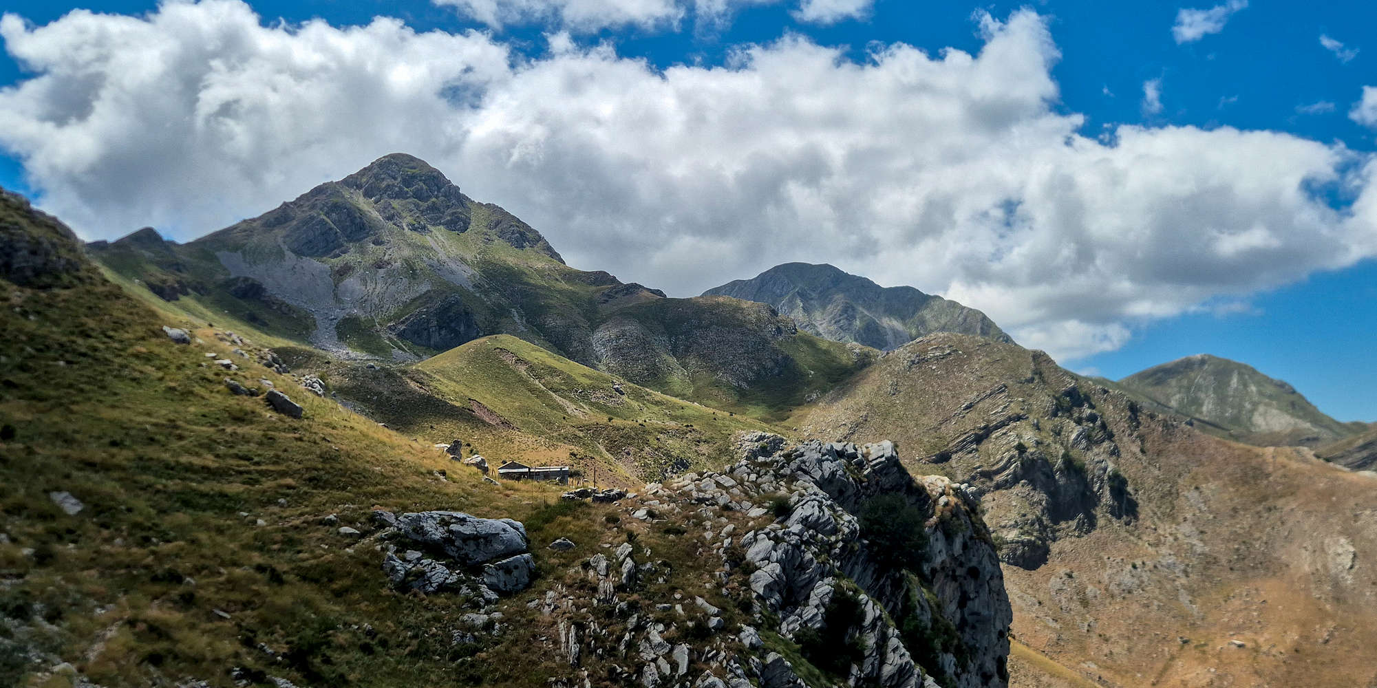 An alpine panorama of Erymanthos (2,223m) under the noon clouds.