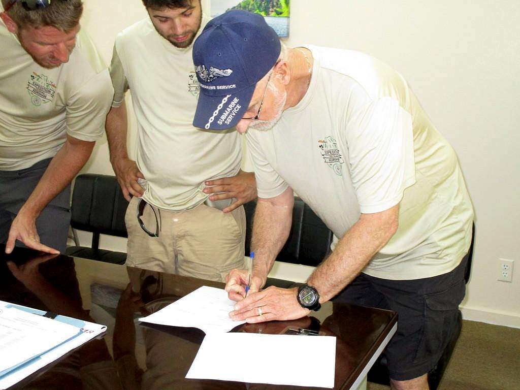 ChuckB signing the MAE with GaryR and JoeM looking on