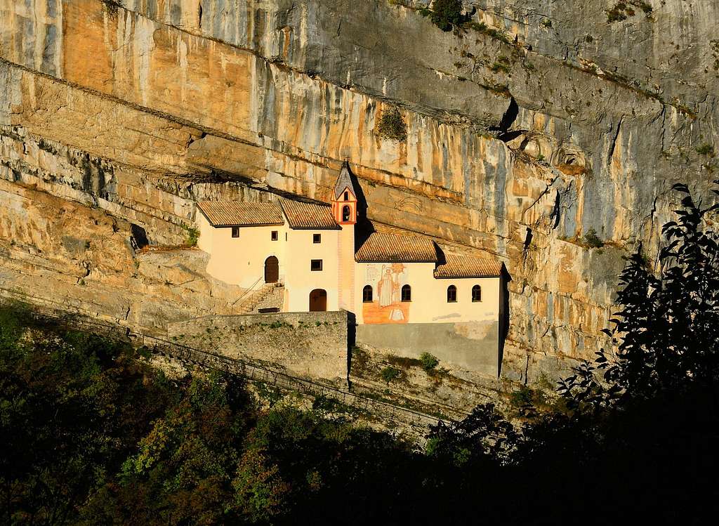 The ancient San Colombano Hermitage suspended on the rocky wall (Vallarsa, Little Dolomites)