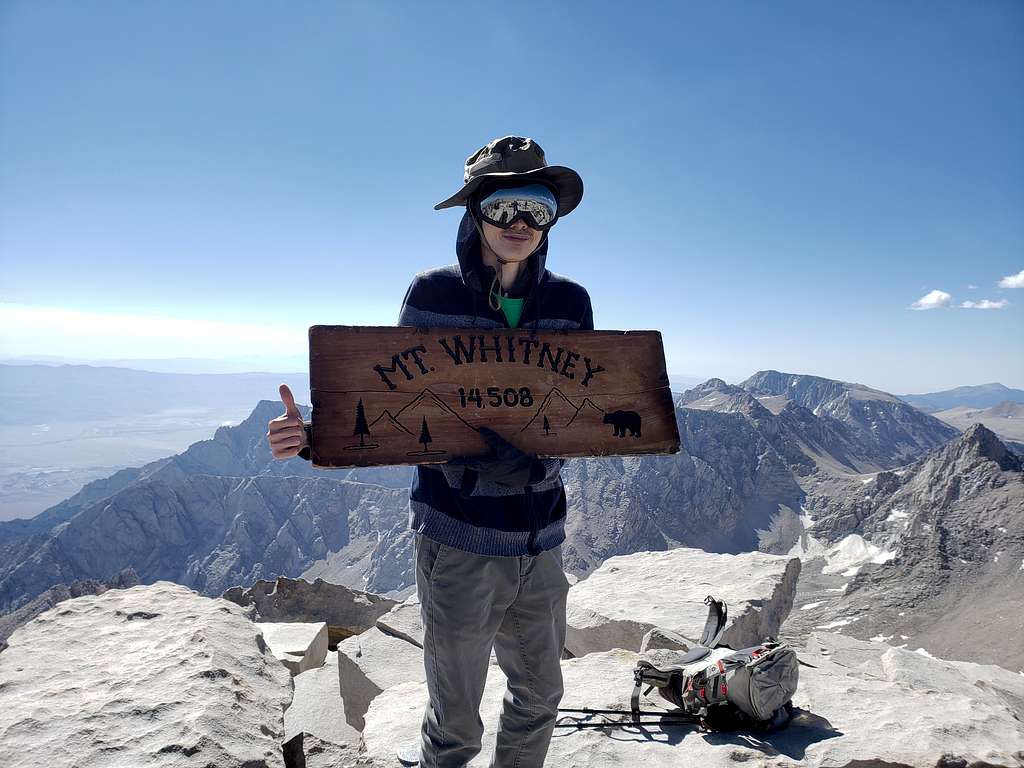 Posing with a sign at the summit
