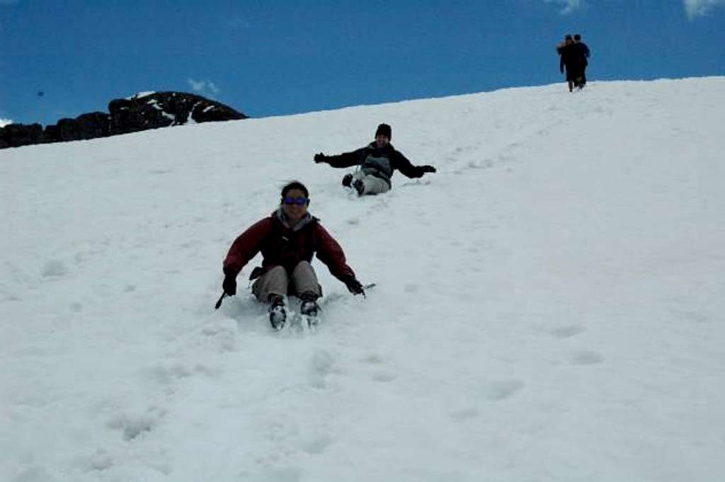 Shari and Lisa glissading down a snow field