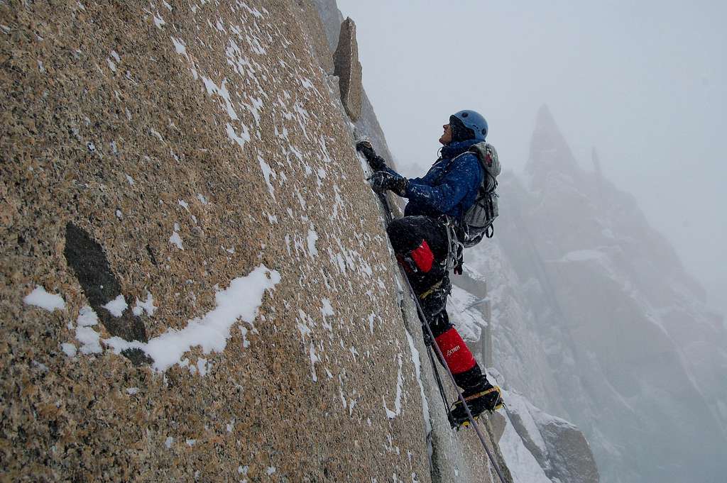 Climbing the aid section on Cosmiques Arête