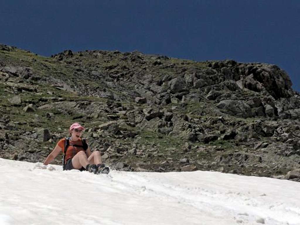 Lisa, glissading down a lengthy snow field to save time on the descent