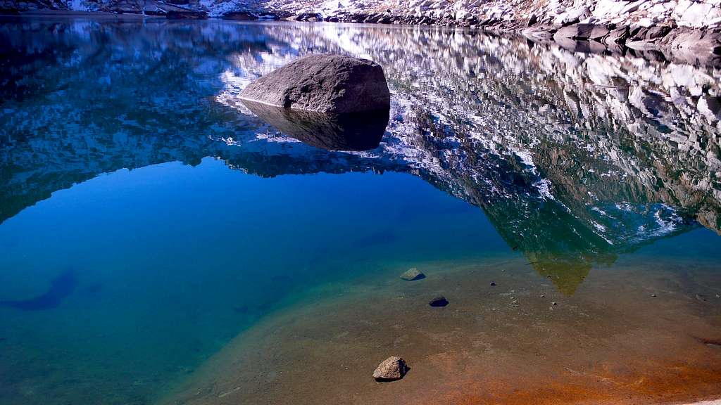 A rock, some water, and a reflection