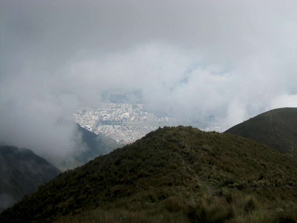 Quito below the clouds while descending Rucu Pichincha