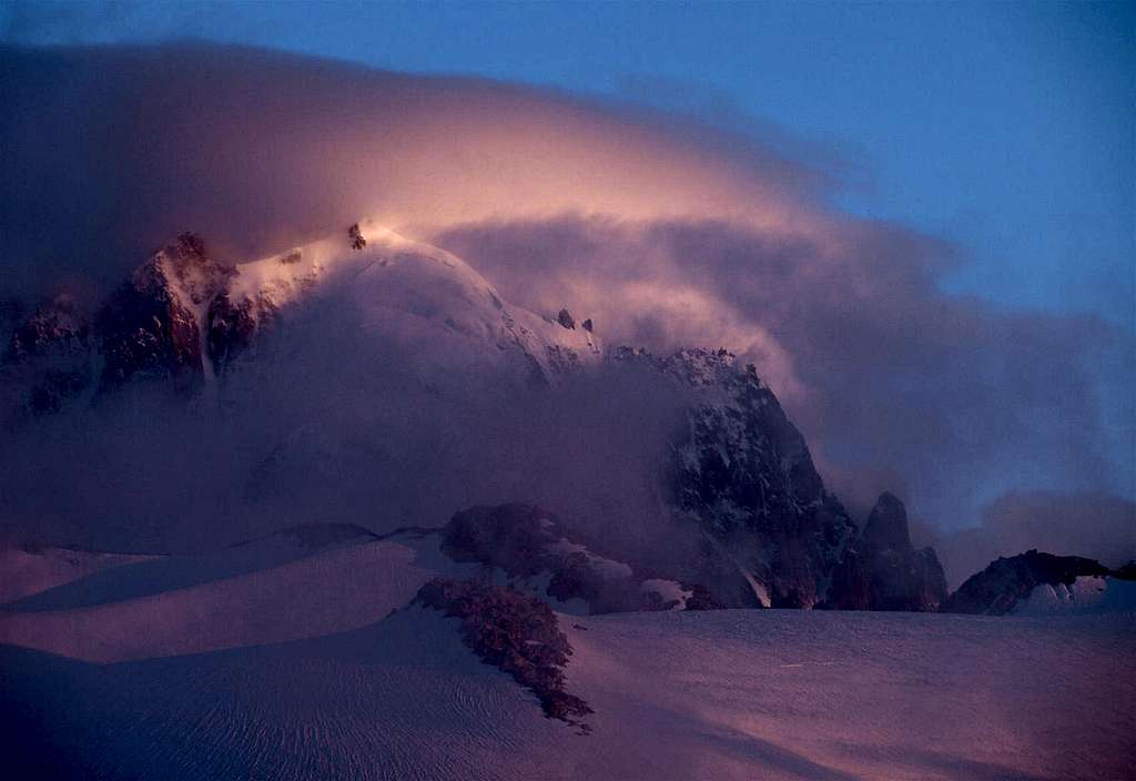 A glowing Aiguille Verte being hugged by cloud