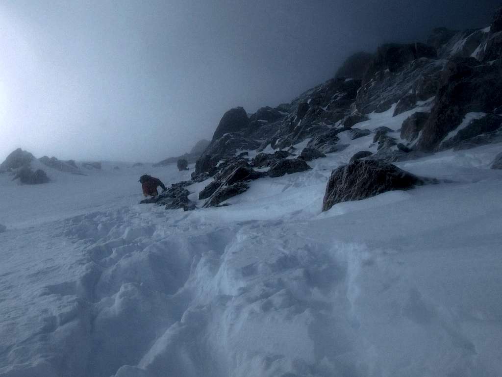 Czechs descending steep snow below summit ridge.
