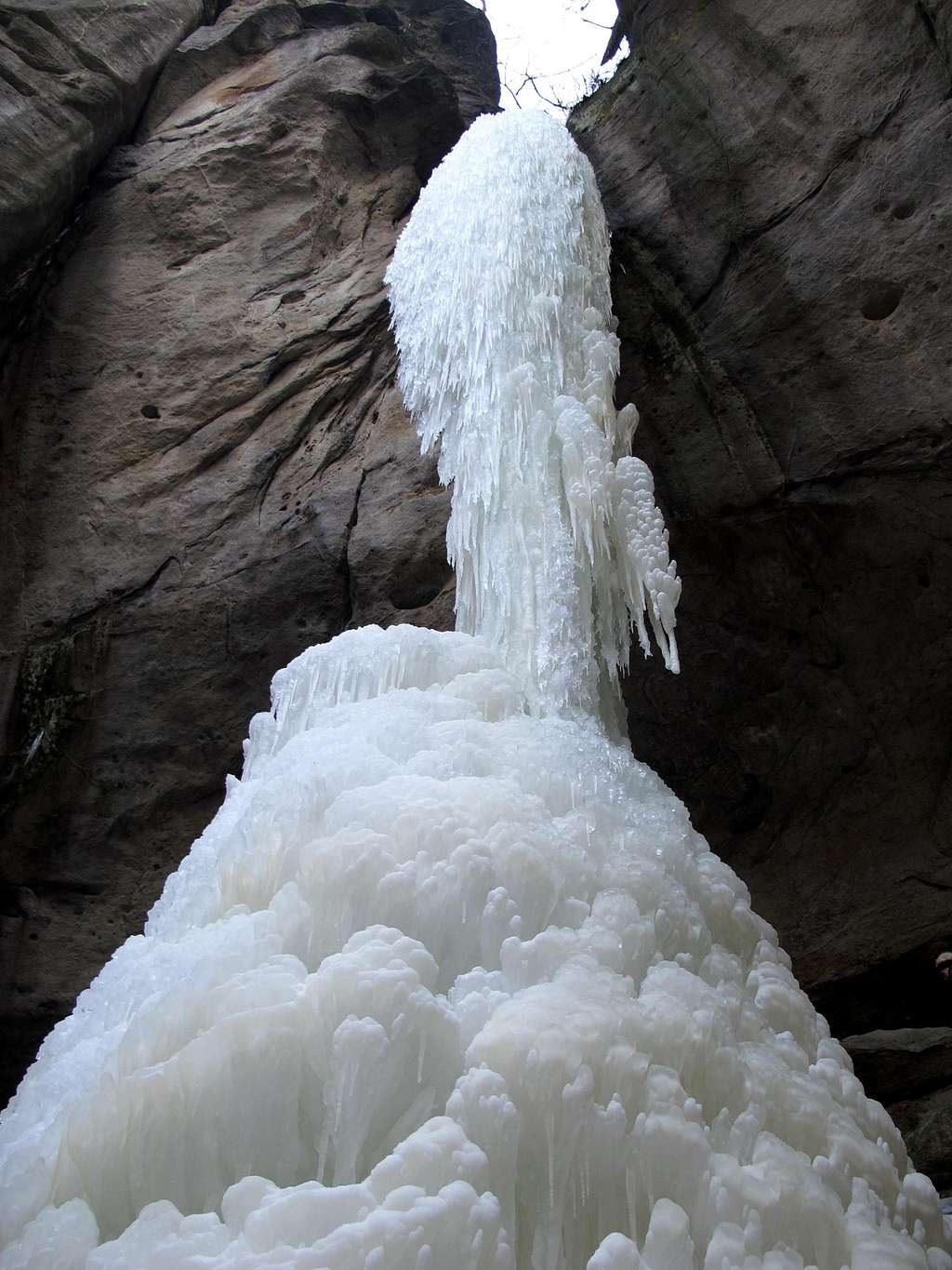 Standing at the base of the frozen waterfall at the Gautschgrotte 
