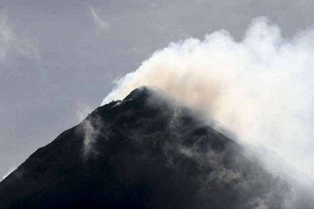 Arenal volcano puffing out smoke on a clear day