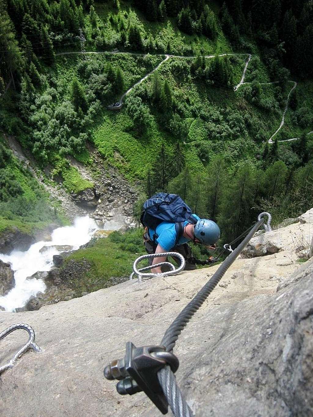 A climber coming up the Stuibenfall Via Ferrata, with the hiking trail deep down below.