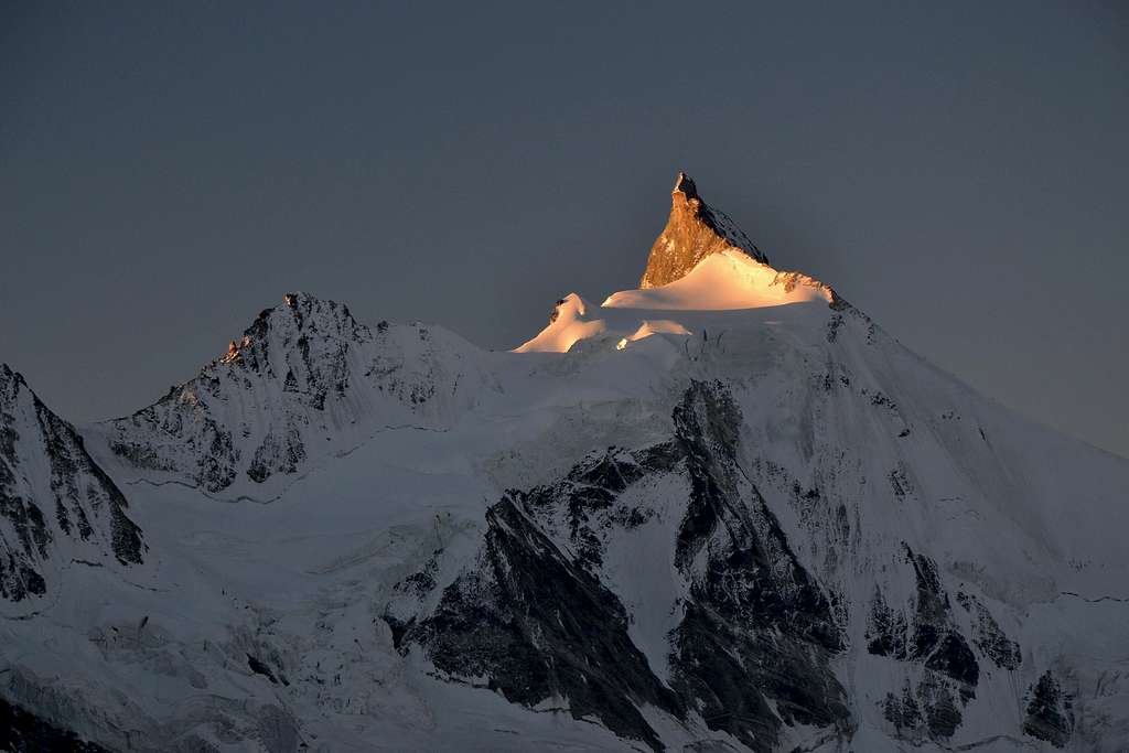 The first sunlight hits the summit rocks of Zinalrothorn
