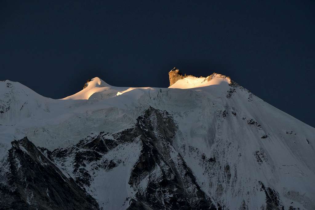The first rays of sunlight touch the top of Zinalrothorn