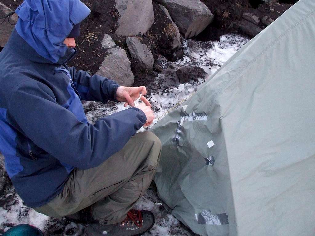 Repairing the tent after it got blown into a ravine.