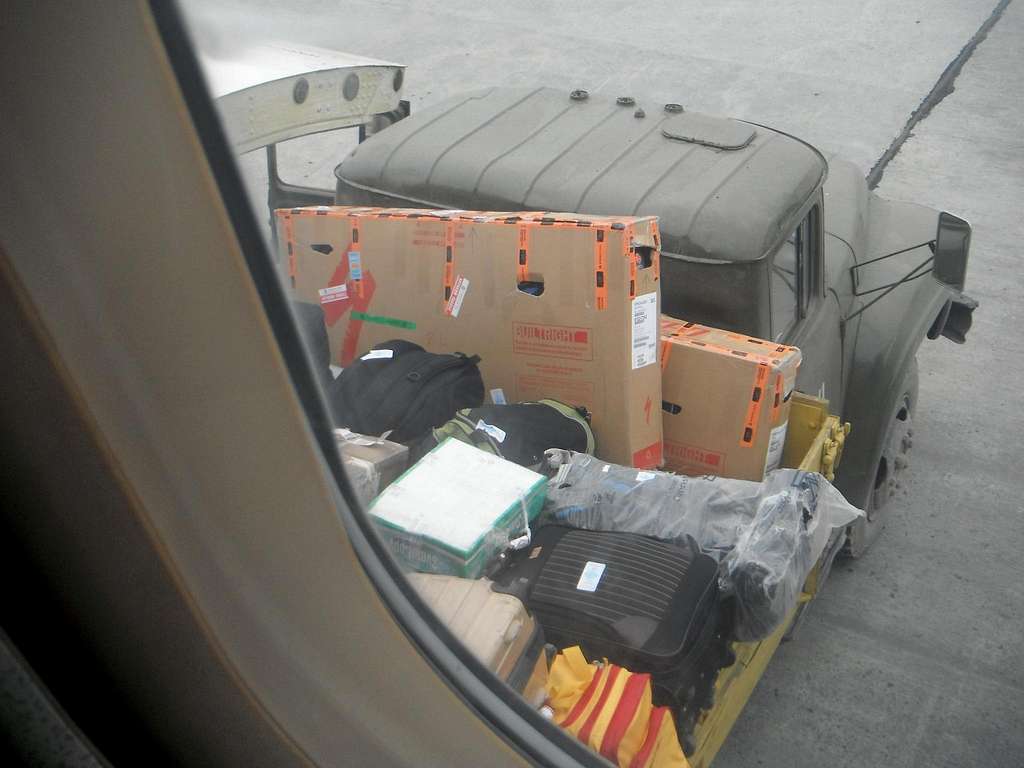 Loading our bicycle boxes and backpacks (clear bag) into the airplane.