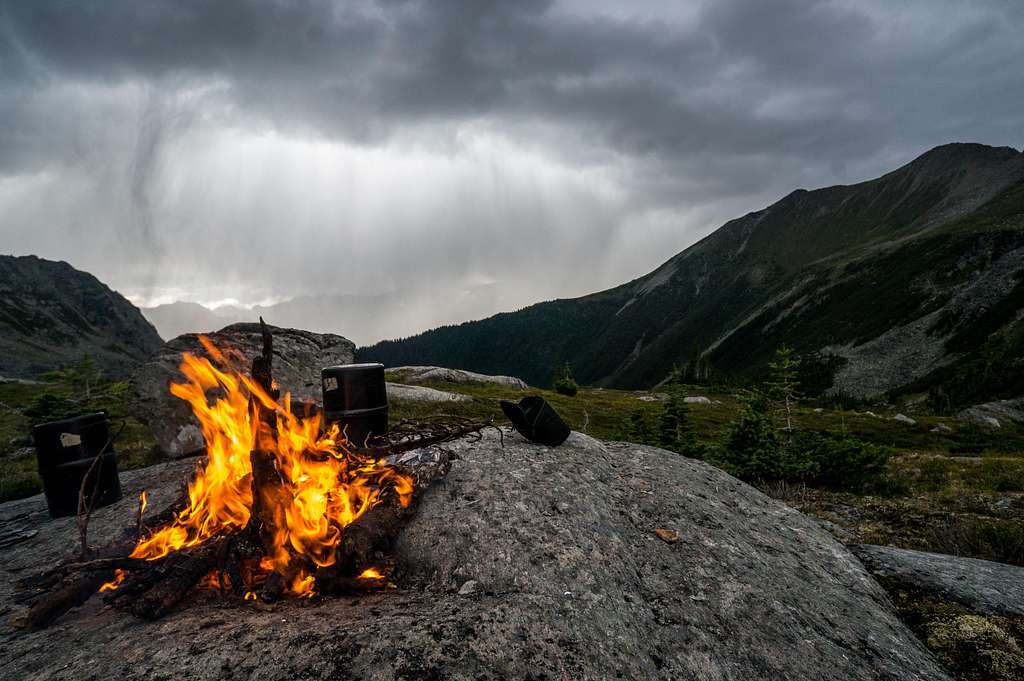Tending to the fire as a hailstorm approaches.