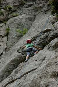 Child climber on a mountain wall