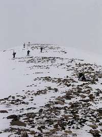 Five skiers approach a very...