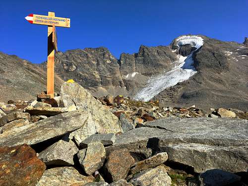 Wooden signpost amidst the high alpine rocks