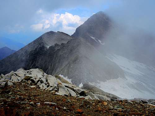 Pizzo delle Vedrette and Monte Nevoso partially wrapped from the clouds seen from the summit of Monte Magro