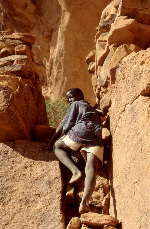 A child climbing to a niche on a wall, Hombori mountains