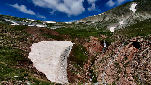 Large snow patch and waterfall below the summit