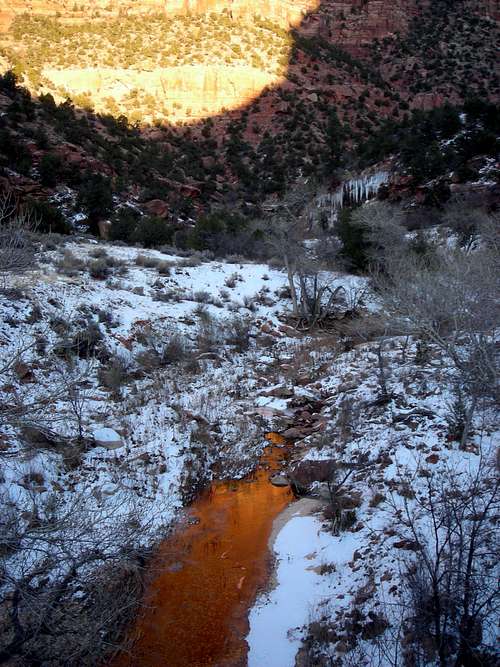 Alpenglow reflecting in half-frozen Pine Creek