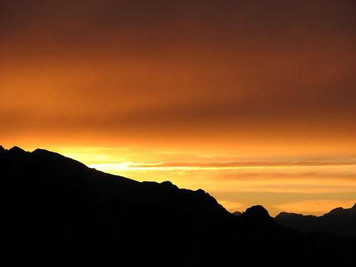 Rising sun above ridge of Monte Disgrazia