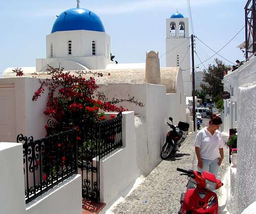 Santorini street scene showing the popular blue-domed cathedrals