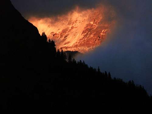 Part of the Ebenefluh in Alpenglow looks through a hole in the clouds