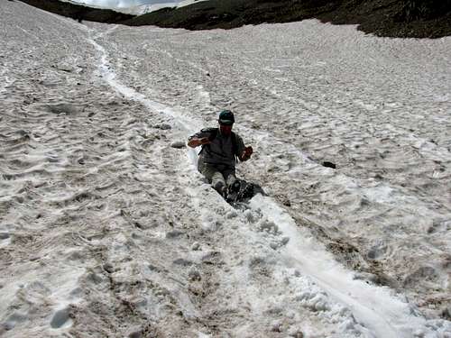 Dad sliding down snowfield