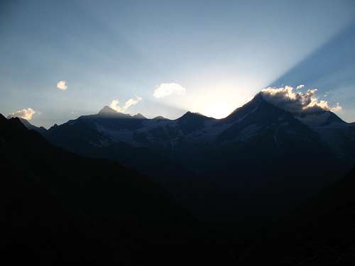 the sun is going down behind Rothorn and Weisshorn