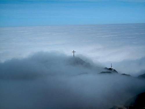 The summit cross of the Geiereck looking above the sea of clouds