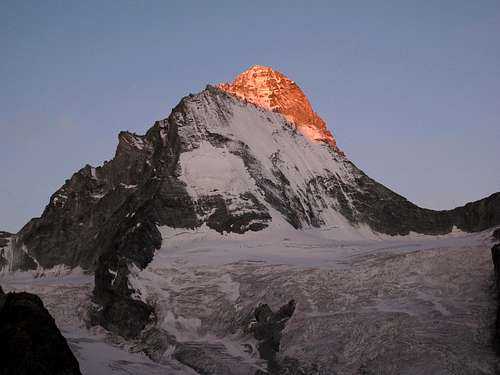 The first rays of sunlight hit the top of Dent Blanche
