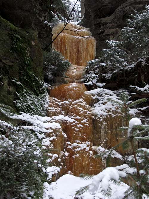 Orange colored frozen waterfall above the Polenztal valley