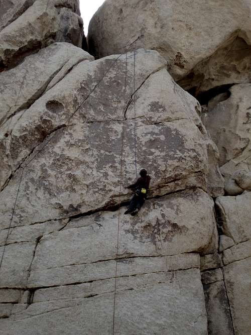 Closeup of a climber on a 5.11 route on Chimney Rock, Hidden Valley Campground, Joshua Tree National Park
