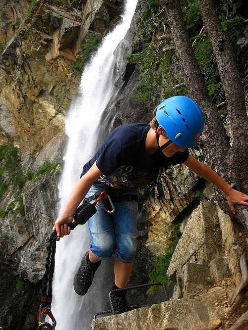 A young kid topping out the Lehner Wasserfall Via Ferrata