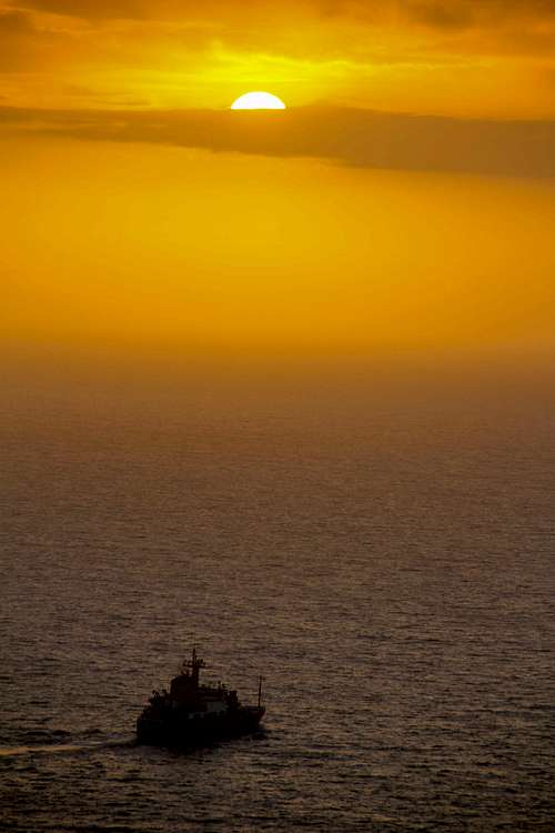 Coast Guard cutter cruises into the sunset