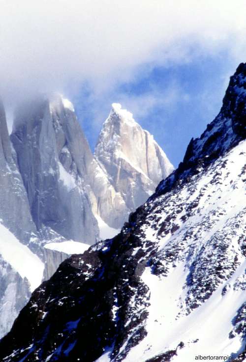 The snowy summit of El Mocho dominated by the gigantic Cerro Torre