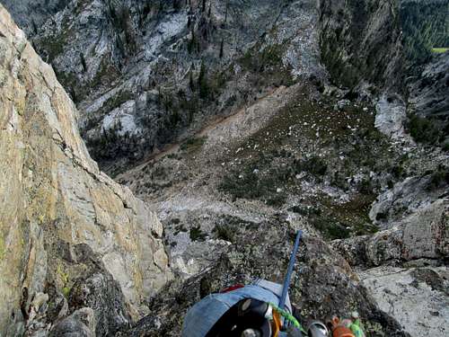 Standing on a ledge 3/4 of the way up pitch 4 above the chimney, Southwest Ridge(YDS 5.7) of Symmetry Spire, Teton Range WY