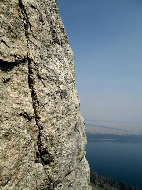 The 5.9+ move of the final pitch of the South Ridge/Face of Baxter's Pinnacle, with Jenny Lake in the background, Teton Range, WY