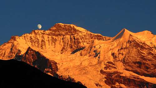 Moon grows up during Alpenglühen at Jungfrau summit